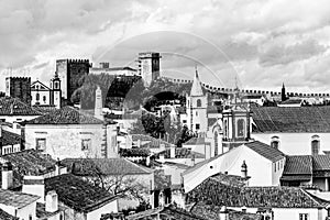 Old town skyline of Obidos, Portugal with house roof tops, church towers and the wall of the medieval castle located in the civil