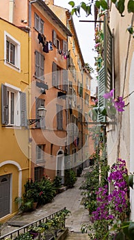 Old town street flowers in alley facade building architecture of Nice on French Riviera