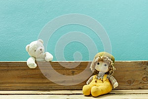 Old toy and Teddy bear on old wood in front blue background