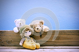 Old toy and Teddy bear on old wood in front blue background .