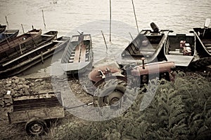 Old tractor and boats by river