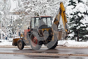 Old tractor cleans snow on city