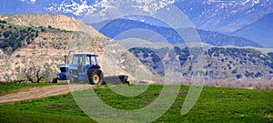 Old Tractor on Farm Field Green with Hills Mountains