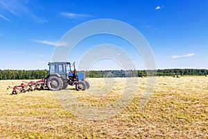 Old tractor in a field in the hay
