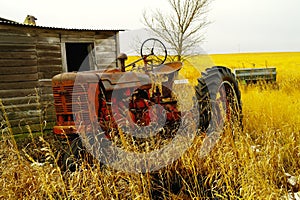 An old tractor next to a shed