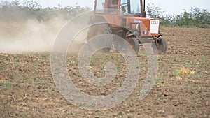 Old tractor plowing field. Slow Motion