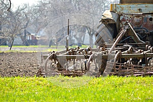 Old tractor plowing field on spring day