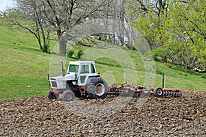 old tractor pulling a cultivator