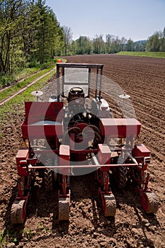 Old tractor with sower parked on worked field upside view