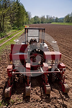 Old tractor with sower parked on worked field upside view photo