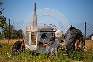 Old tractor standing on the field photo