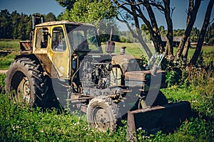 Old tractor working in the field in a rural area