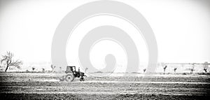 Old tractor working planting in a field.