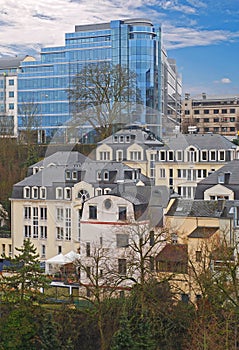 Old traditional buildings in Grund quarter, central Luxembourg City with ArcelorMittal modern office in background
