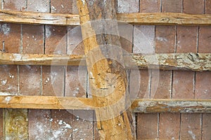 Old traditional italian wooden ceiling with damaged wooden beams, rafters and terracotta tiles clay bricks