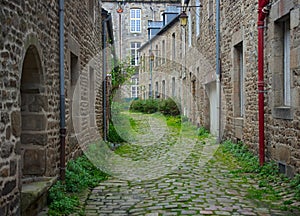 Old traditional narrow alley with houses made of stone in small french town