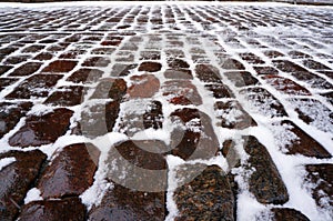Stone pavement covered with snow in winter