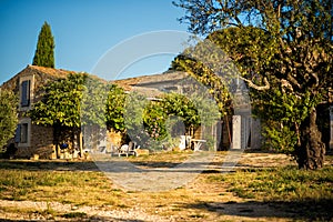 Old traditional stone provencale backyard of farm in Provence, France with Luberon hill on background in hot summer morning with