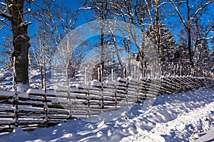 Old traditional Swedish wooden fence in winter sunny day.