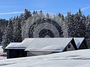 Old traditional swiss rural architecture and alpine livestock farms in the winter ambience of the tourist resorts in the Alps