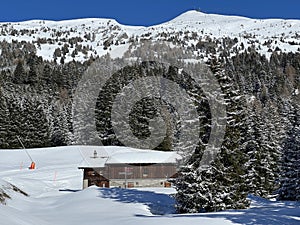 Old traditional swiss rural architecture and alpine livestock farms in the winter ambience of the tourist resorts in the Alps