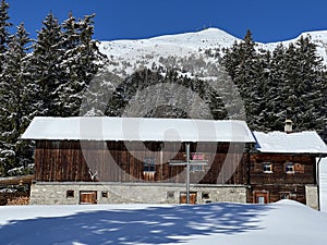 Old traditional swiss rural architecture and alpine livestock farms in the winter ambience of the tourist resorts in the Alps