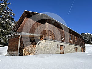 Old traditional swiss rural architecture and alpine livestock farms in the winter ambience of the tourist resorts in the Alps