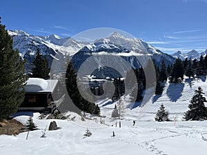 Old traditional swiss rural architecture and alpine livestock farms in the winter ambience of the tourist resorts in the Alps