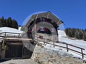 Old traditional swiss rural architecture and alpine livestock farms in the winter ambience of the tourist resorts in the Alps