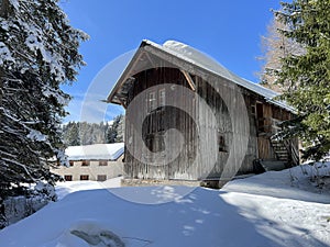 Old traditional swiss rural architecture and alpine livestock farms in the winter ambience of the tourist resorts in the Alps