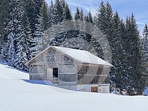 Old traditional swiss rural architecture and alpine livestock farms in the winter ambience of the tourist resorts in the Alps