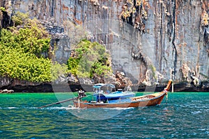 Old traditional Thai motorboat made of wood for fishing and tourists on excursions in the Andaman Sea near Phi Phi Leh island in