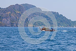 Old traditional Thai motorboat made of wood for fishing and transporting tourists on excursions in the Andaman Sea in clear