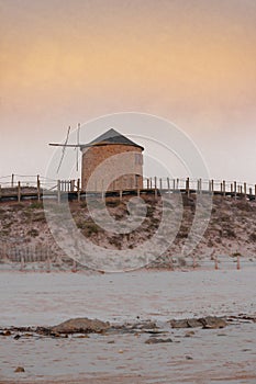 Old traditional wind-mills in sand-hills of Apulia Portugal.