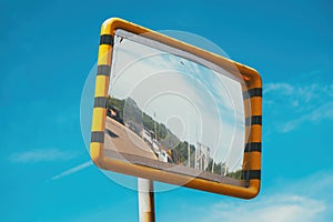 Old traffic mirror with yellow plastic frame