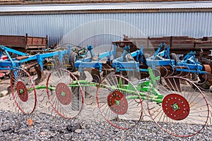 Old trailed plough for tillage are standing near the arches hangar on the material and technical base of the agricultural