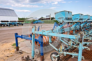 Old trailed seeder are standing near the arches hangar on the material and technical base of the agricultural enterprise. Farm