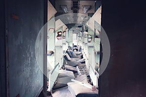 In the old train cabin, there is a broken seat, vintage color tone.