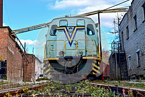 Old train, diesel locomotive stands on rails with freight cars in an industrial zone of a plant or depot