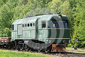 Old train and locomotive. Railroad tracks stretches and green grass and trees. Railway road environment background.