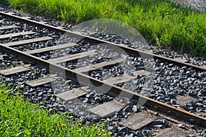 Old train railway tracks with green lawn.