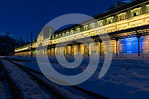 Old train station of Canfranc on a winter night with snow on the tracks, Huesca, Spain