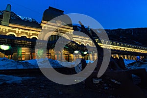 Old train station of Canfranc on a winter night with snow on the tracks, and a switching points in foreground. Huesca, Spain