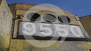 Old train unusual structure metal numbers 9550 yellow peeling paint blue sky three holes