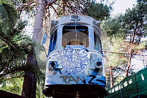 Old tram abandoned and vandalized in a park by young graffiti artists