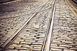 Old tram rails with exchange of track and direction agaisnt a stone road Ireland-Europe  -Tilt-shift filter added