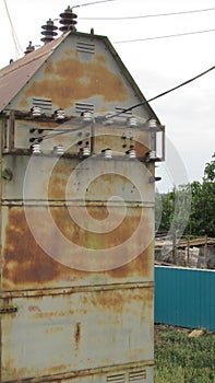 Old transformer with white porcelain insulators