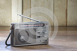 Old transistor radio on wood background.