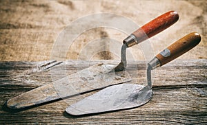 Old trowels on wooden background