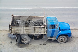 Old truck with a blue cabin.